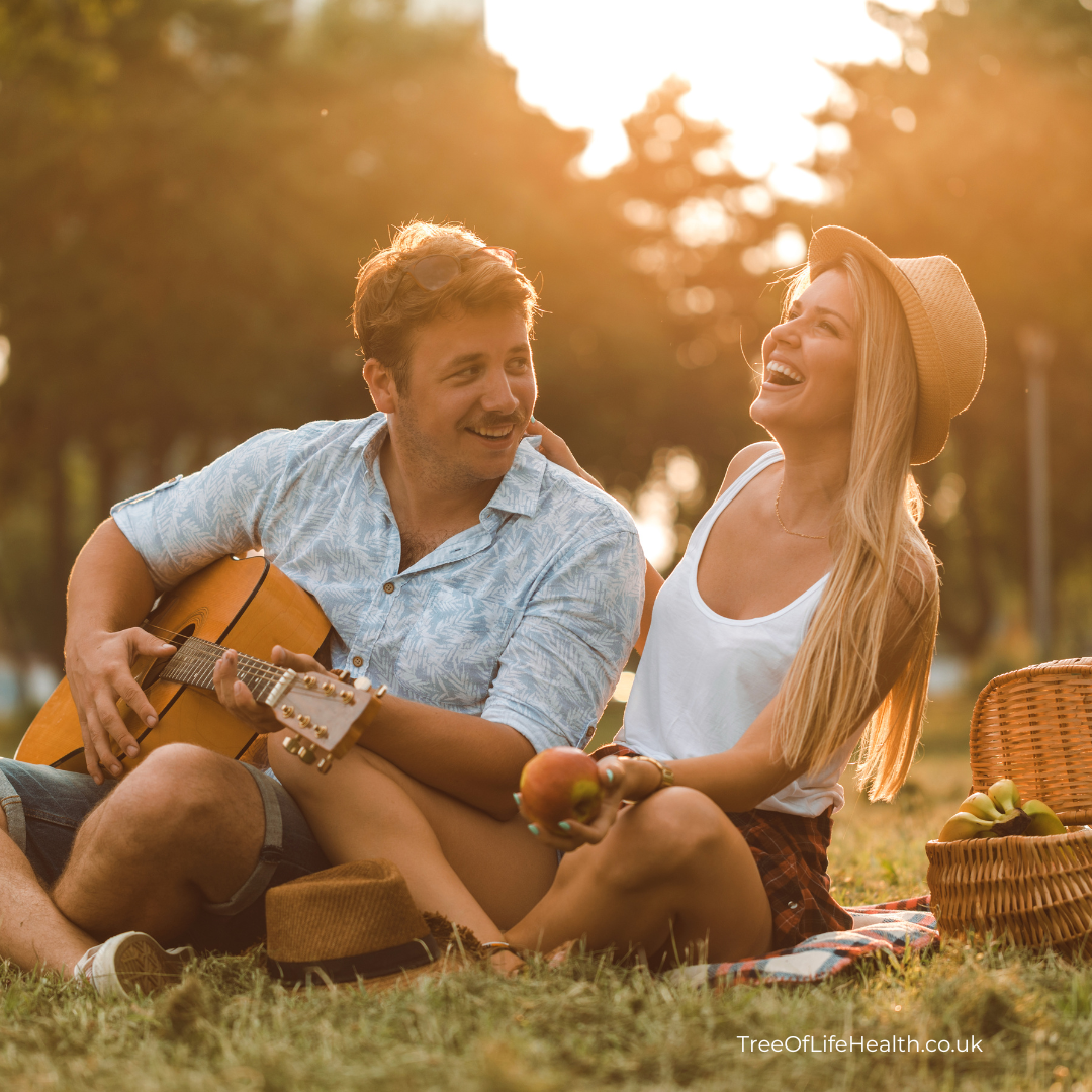 image of couple enjoying healthy habits outdoors with guitar and picnic. from TreeOfLifeHealth.co.uk